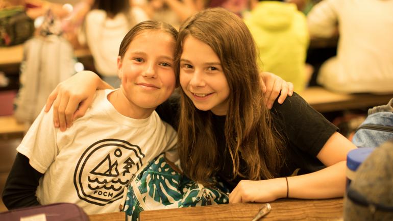 Female middle school students pose for the camera at lunch