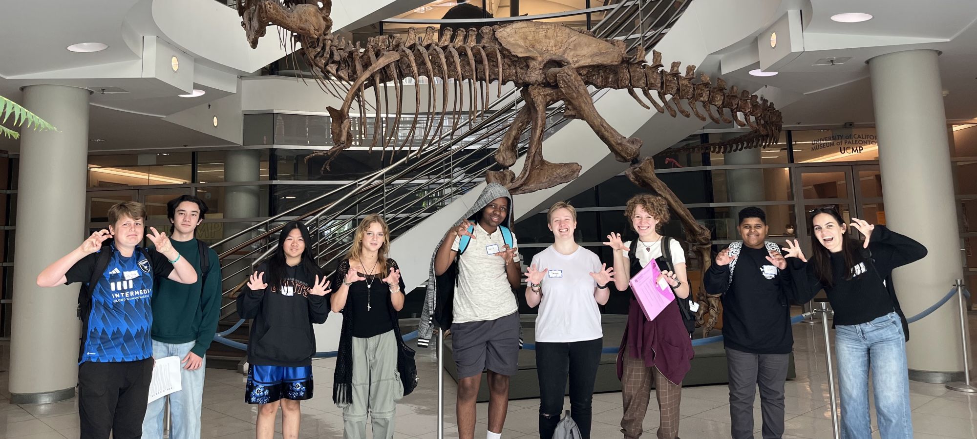 students pose with t rex