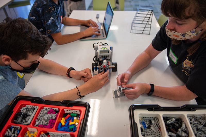 a student and volunteer make a lego robot