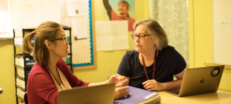 teachers discussing over a laptop